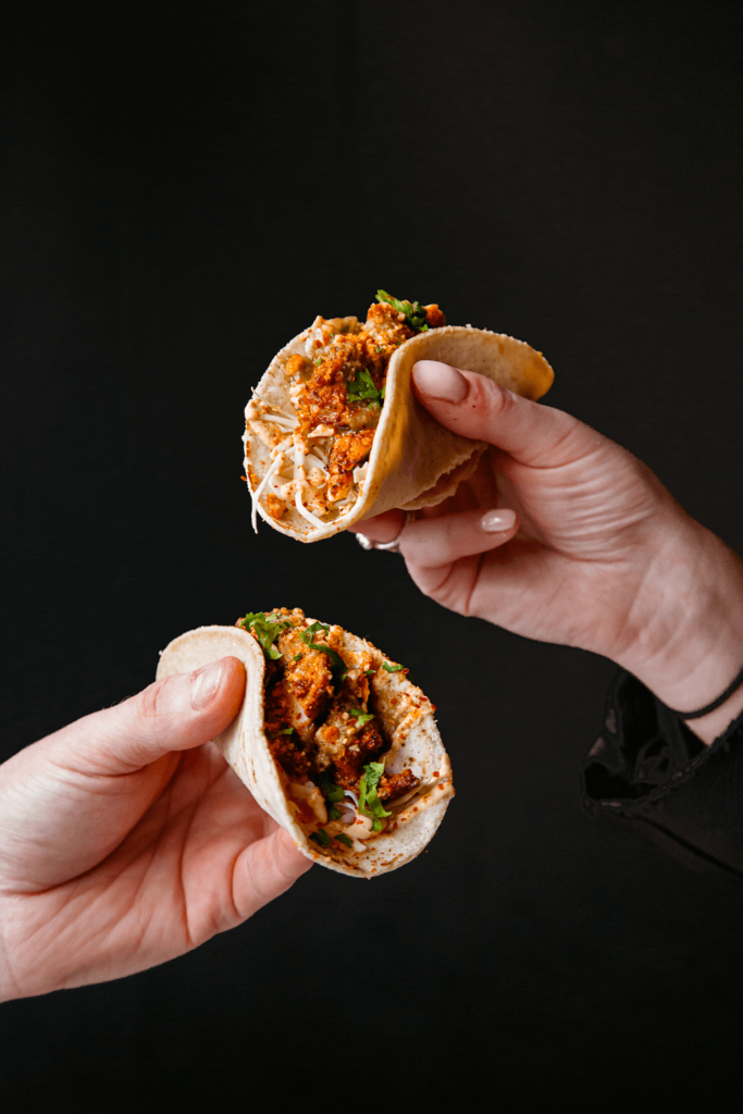 Two hands holding tacos